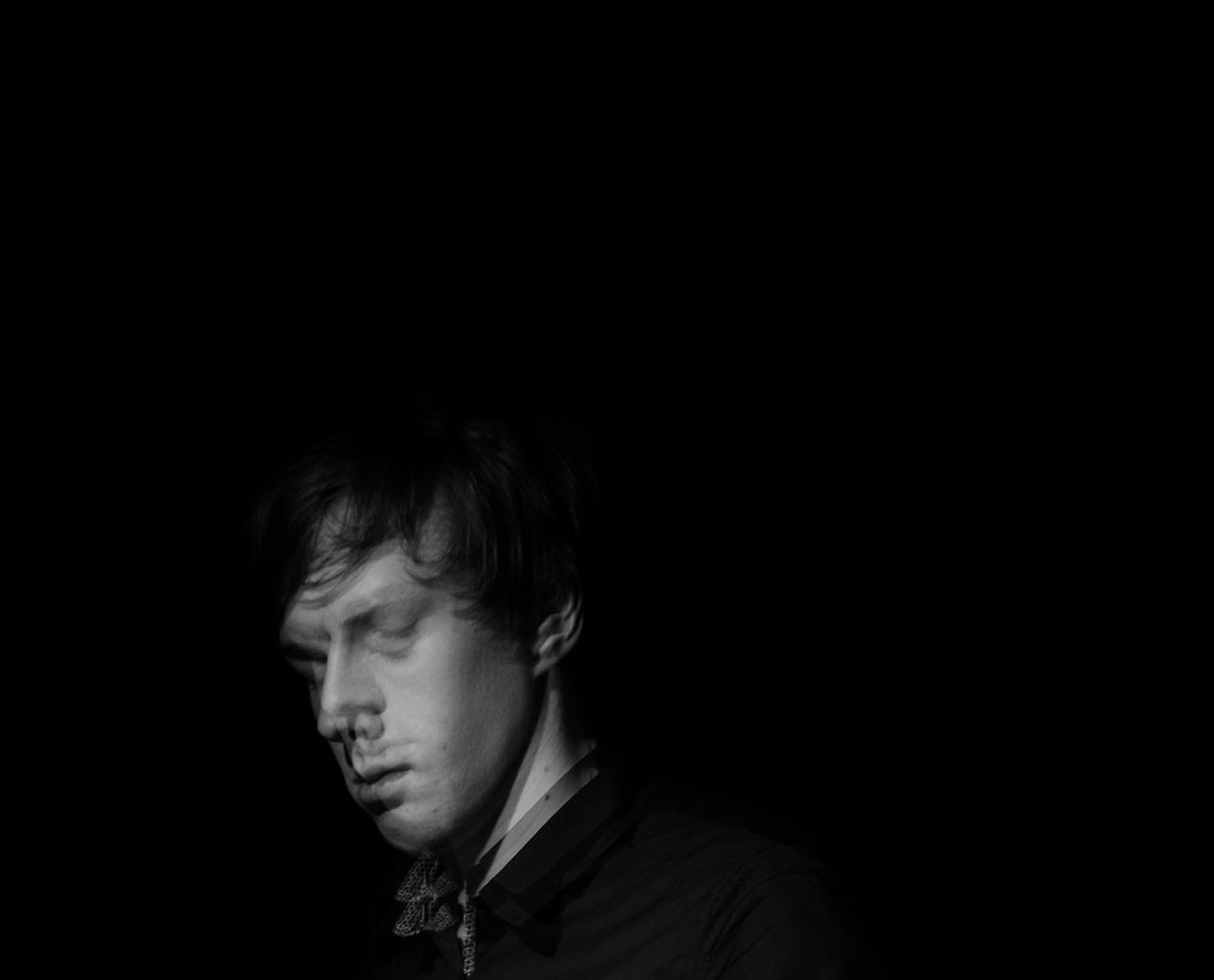 about-us-01 Artistic black and white portrait with blurred motion effect, expressing introspection.